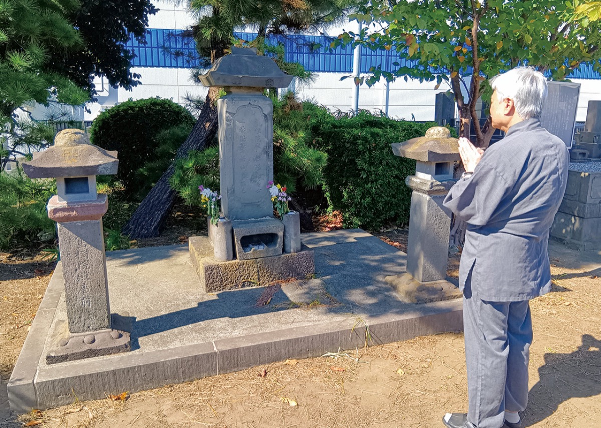 墓碑に手を合わせる大橋さん