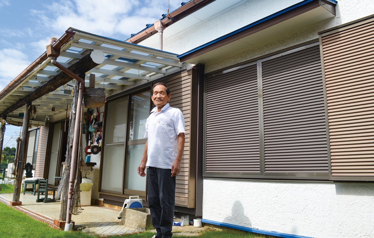自ら建てた家の前に立つ斎藤さん