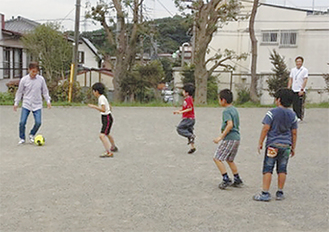地域の子どもとサッカーをする若年性認知症の男性（左端）