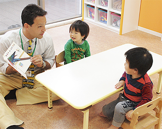 保育室で子どもと触れ合うカラシュ施設長（左）