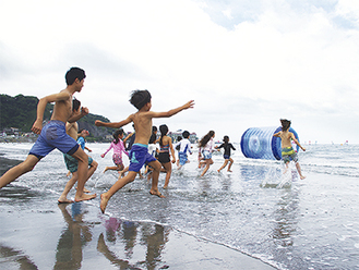 海開き式が終わり、水上遊具に向かって走る子どもたち