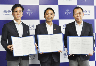 右から小泉取締役社長、松尾市長、山本執行役員