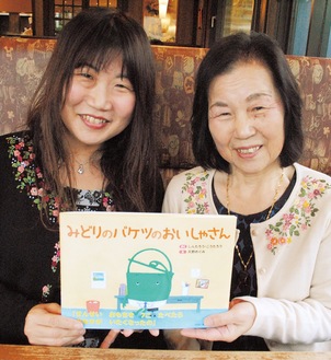 自身が手掛けた絵本を手にする長谷川正子さん（右）と娘の育子さん
