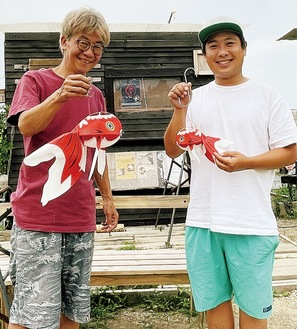 山口県柳井市の民芸品「金魚提灯」を持つ眞下代表（左）と細内佑亮さん