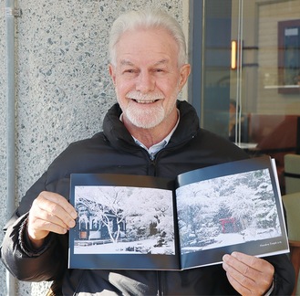 写真集とピーターさん。開いたページは雪化粧の長谷寺