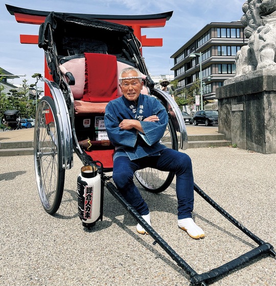 相棒の５台目の人力車とともにほほえむ青木さん