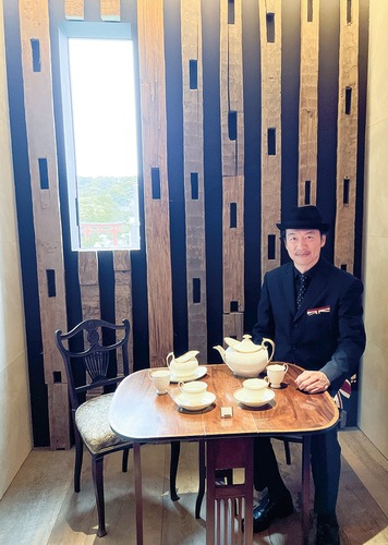 茶室「惹採庵」で取材に応える土橋館長。壁面には約800年前の土台角材が展示され、同時代の英国邸宅で使用されていたオーク材を床材にした