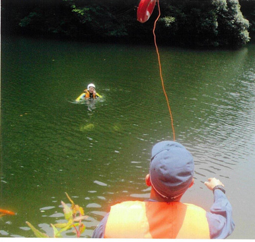 救助者に浮き輪を投げる警察職員（訓練・提供）