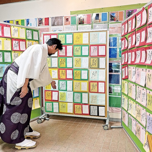 上／参拝者から寄せられた「和歌」を紹介する小岩宮司、下／子どもや学生からと思われる作品