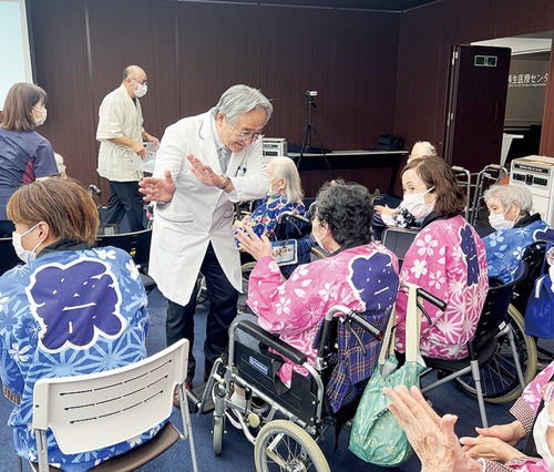 参加者と一緒に体を動かす小林院長（中央）