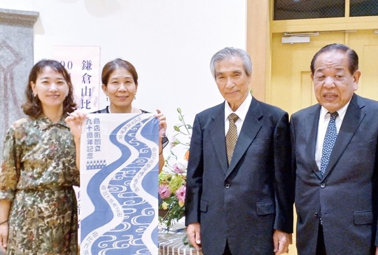 オリジナルの手ぬぐいと同商店街会員。右端が堀理事長