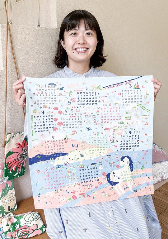 江ノ電沿線の魅力が散りばめられたファブリックカレンダーを持つ伊藤さん