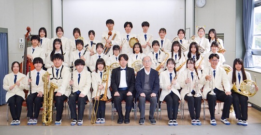 七里ガ浜高校吹奏楽部のメンバー。前列中央が指揮者の石井さん（左）と顧問の玉井教諭