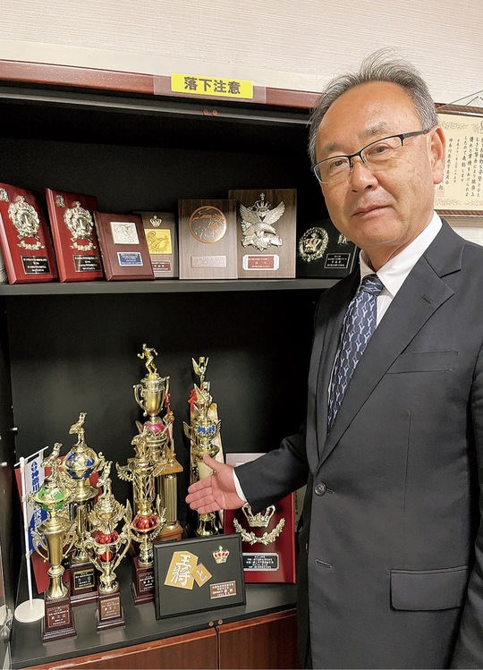 トロフィーや盾を紹介する与安校長