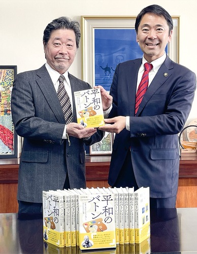 著書を手にする弓狩さん（左）と松尾市長