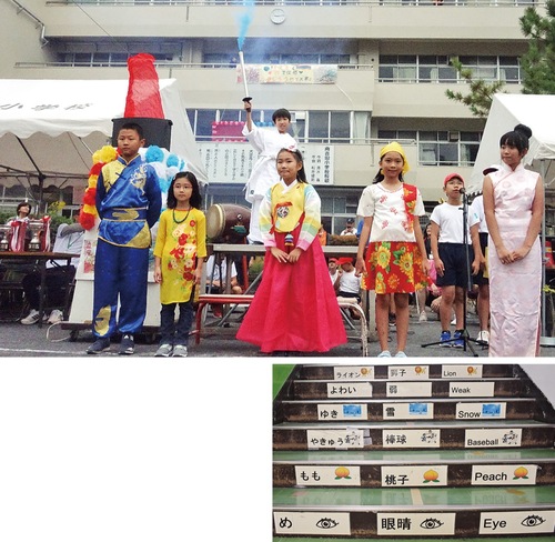 過去の運動会では各国の民族衣装を着て聖火リレーをしたことも（同校提供）＝写真上＝、校舎の階段には多言語の単語を表示＝同下＝