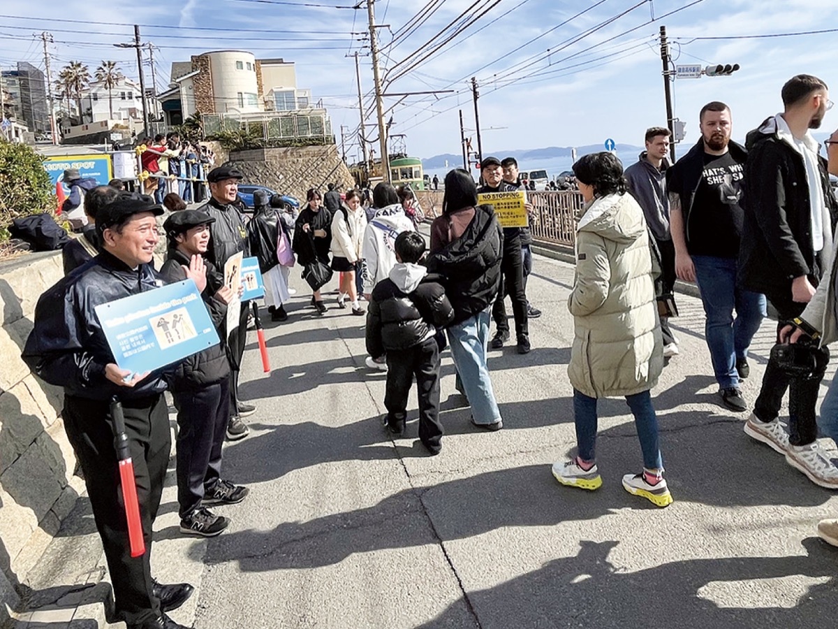 鎌倉高校前駅の乗降客にマナー啓発を呼び掛ける、鎌倉ガーディアンズのメンバー