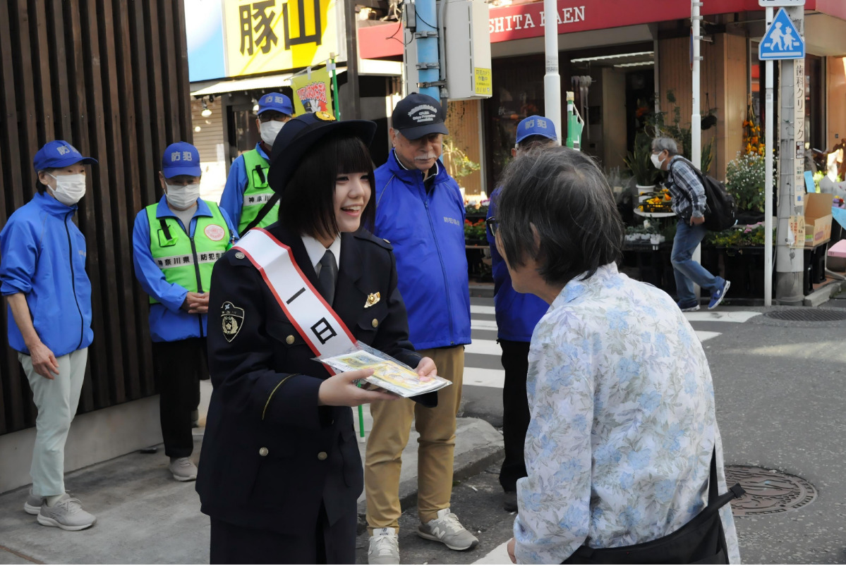 啓発グッズを配布する高橋さん