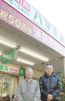 土井会長（右）、あさひ屋商店の泉さん（左）。各店舗の軒先には「祝50周年」の横断幕を掲げている
