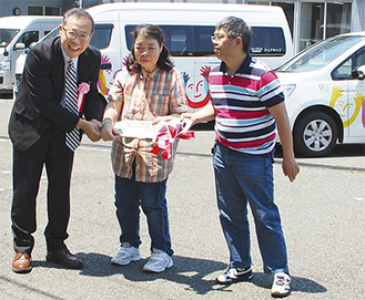 池内さん（左）が利用者代表へキーを手渡した＝５月26日・福祉総合援助施設「空と海」にて