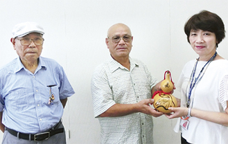 作品を手渡した久保会長（中央）と寺嶋さん（左）