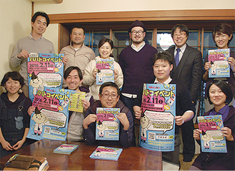 ポスターを手にする実行委員長の西村誠さん（前列中央）ら準備を進めている実行委員会のメンバー