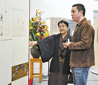 展示作品を説明する松永会長とブランドンゴウダさん（左から）