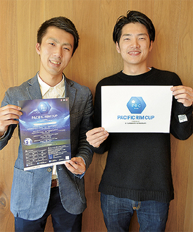 ポスターを持つ山本さん（左）とロゴを持つ平松さん
