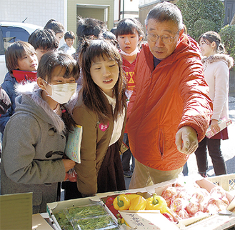 野菜を前に児童の質問に答える宍倉さん（右）