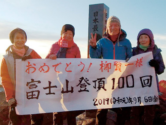 登頂100回を喜ぶ柳さん（右から２番目）と山仲間たち