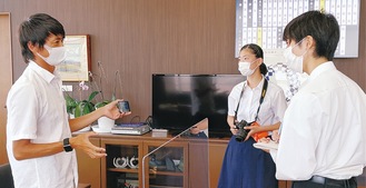 藤沢市議会議長（左）を取材する板倉さん（中央）と吉富さん