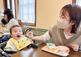 「赤ちゃん食堂」で離乳食を頬張る乳児
