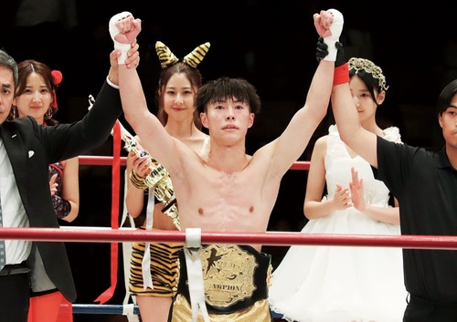 タイトルマッチで勝利し、ベルトを巻き拳を上げる黒川選手＝本人提供