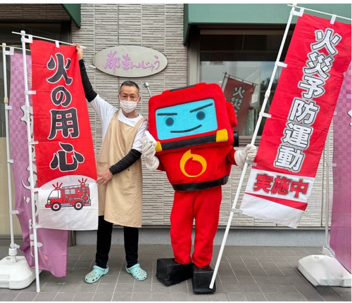 火災予防を訴えるすずやの店主（左）とショウボーグ１１９号＝提供