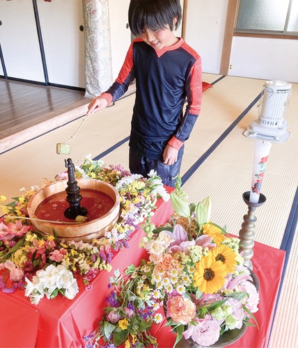 釈迦像に甘茶をかける子ども