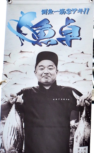 ｢魚卓｣のリニューアルオープンを記念したフラッグ＝３月、茅ケ崎駅南口の雄三通り