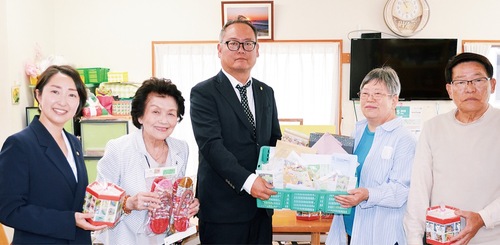 渡邊理事長（右から２人目）に切手を手渡す原田会長