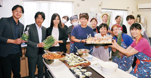 子ども食堂運営者にパンを手渡す祖父江選手（中央）