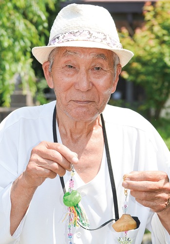 キーホルダーを手にする田中さん