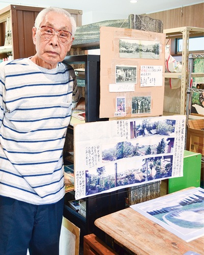 当時住んでいた御所見村の写真を手にする佐藤さん