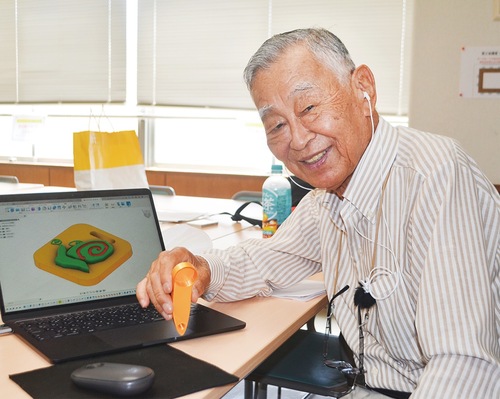 自らデザインした補助器具を手にする柳川さん