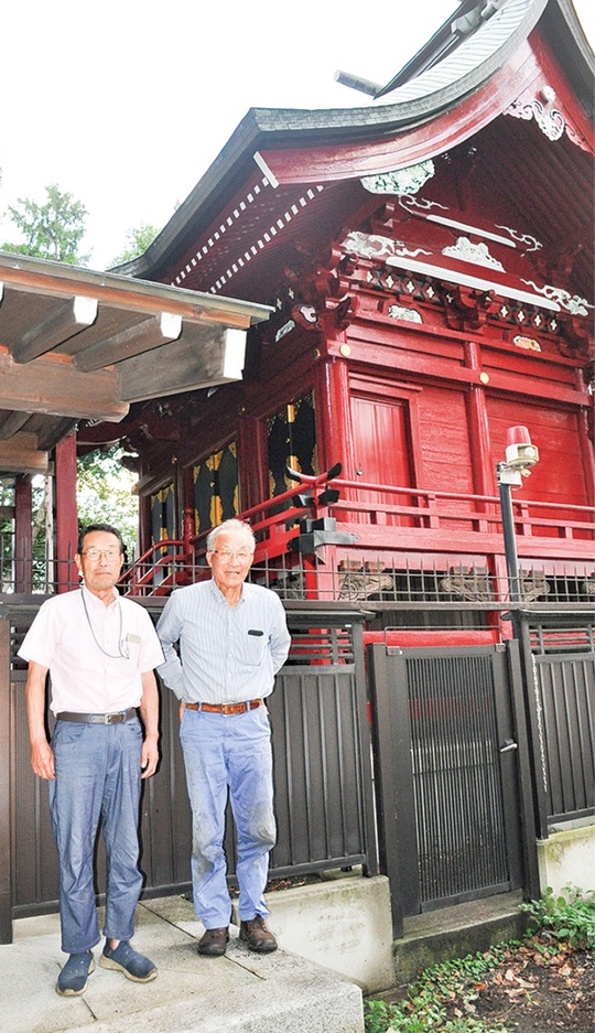 修復した本殿を前に笑顔を見せる委員会メンバー