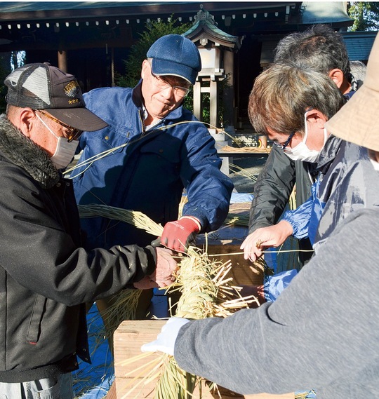 藁を編む同神社の関係者ら