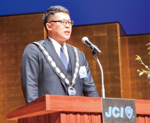 あいさつする羽場理事長