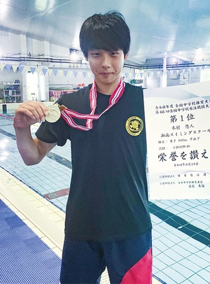 メダルと賞状を手に笑顔を見せる木村悠人さん