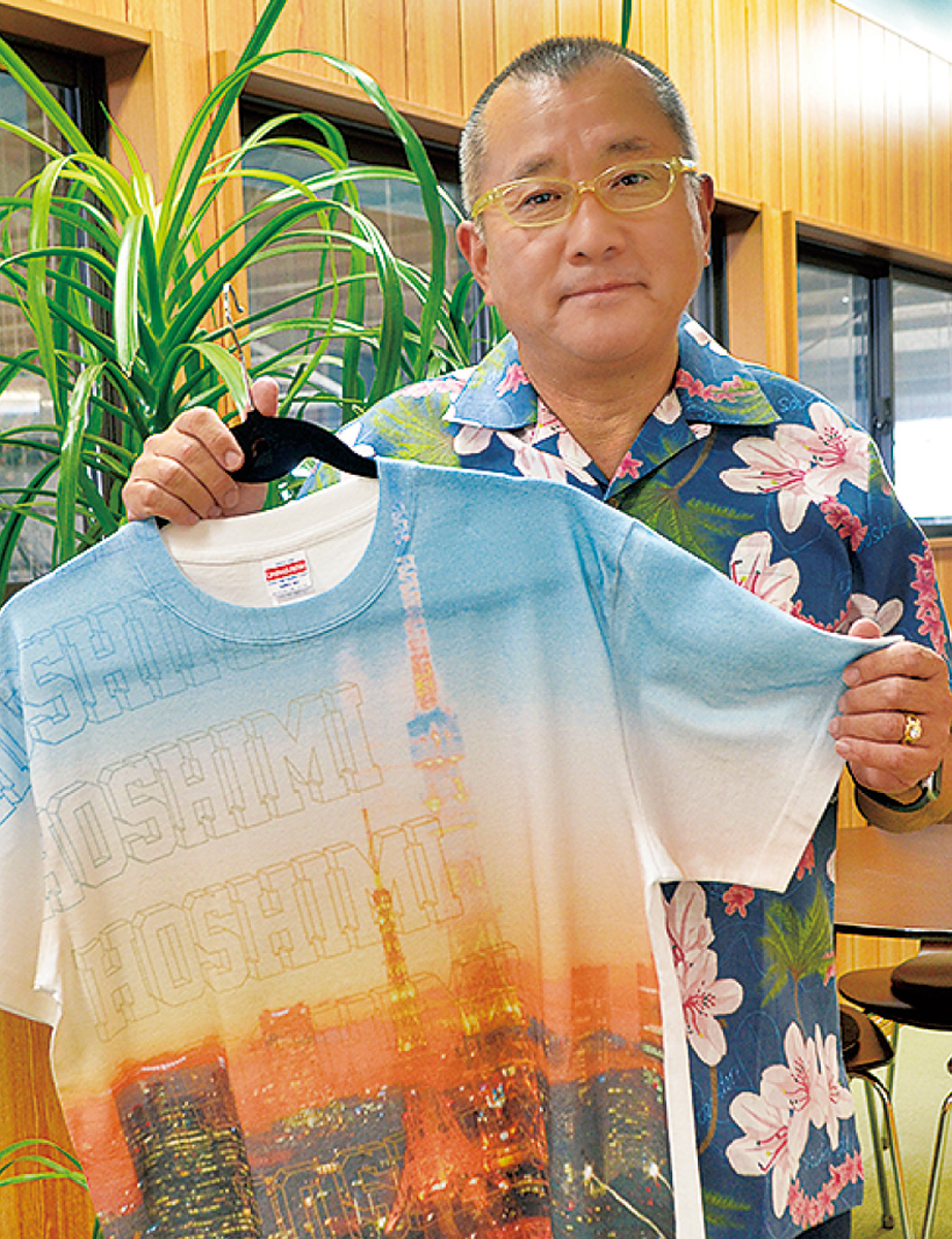 製品を掲げる金子社長