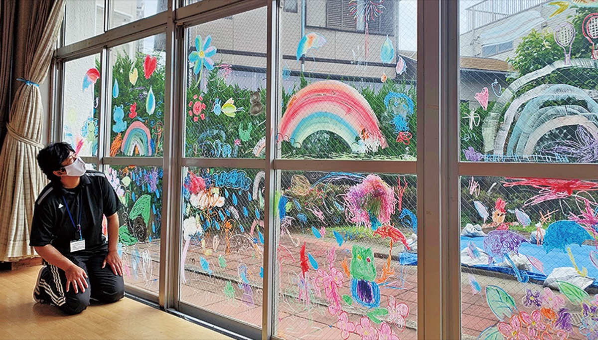 園児が描いた絵を見つめる浅井館長