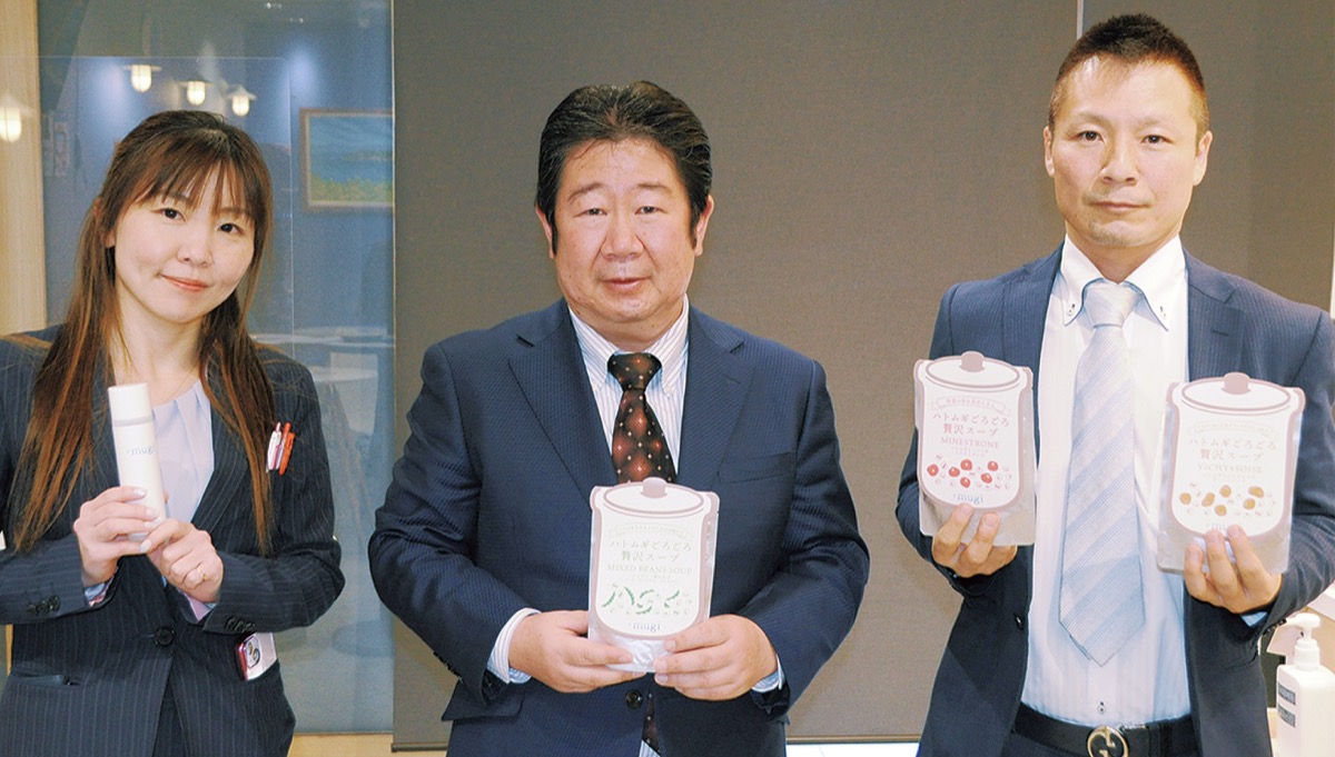 商品を手にする田中重光社長(中央)ら同社社員