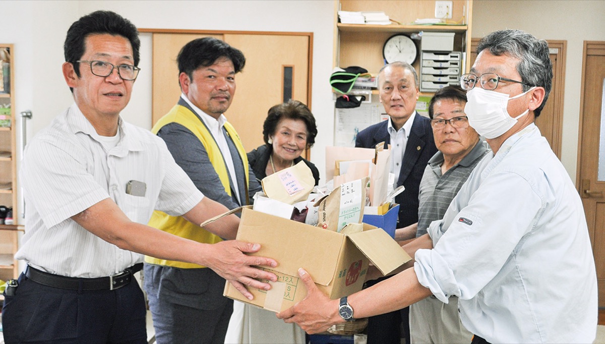 使用済み切手を手渡す会員ら