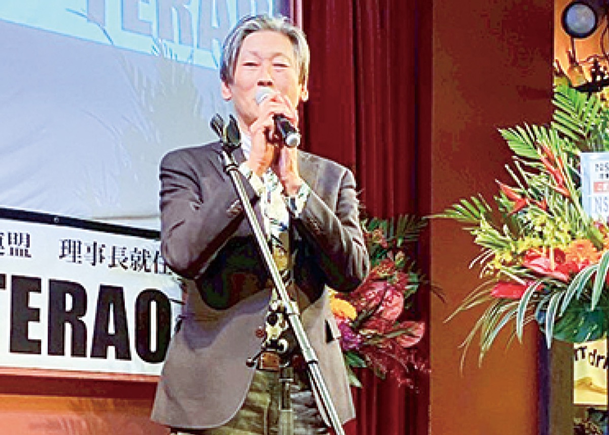 壇上に立つ寺尾理事長＝提供